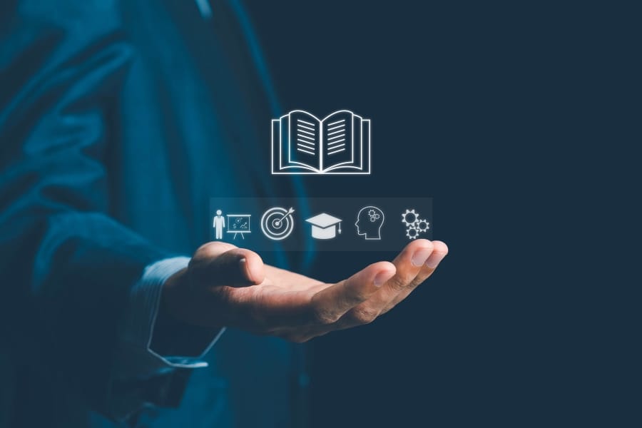A stylised image of a hand holding images representing learning, goals, and sales
