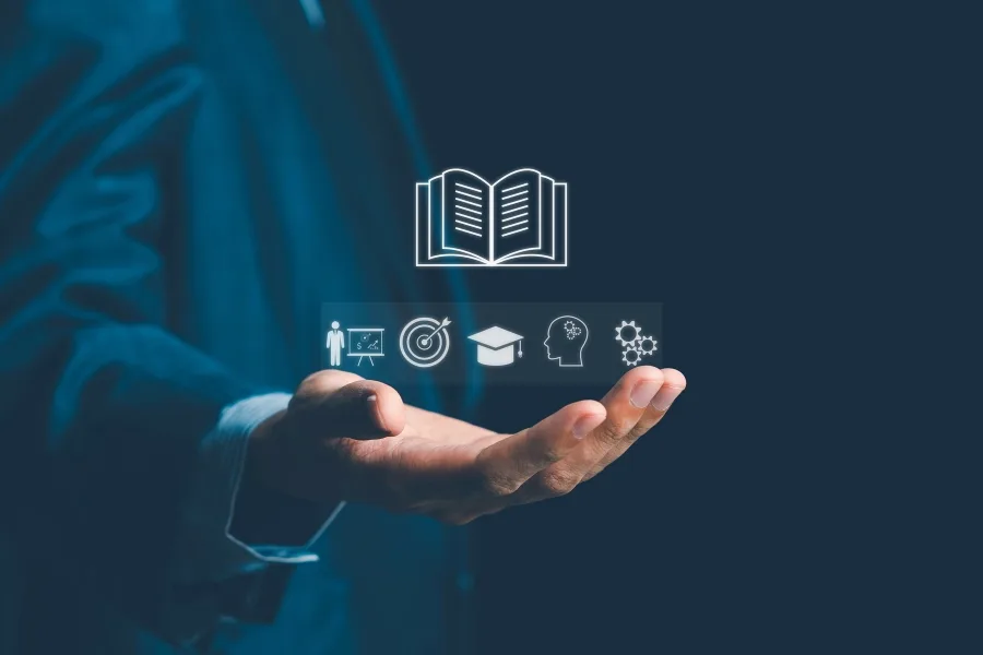 A stylised image of a hand holding images representing learning, goals, and sales