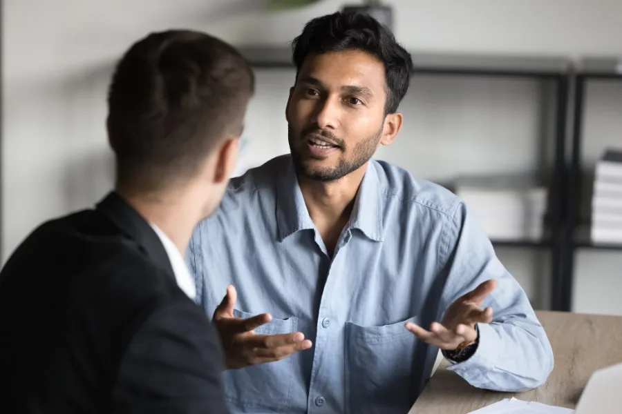 Two men discuss the GROW coaching model