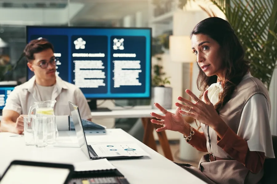 Improve Coaching effectiveness: Business coach leading a discussion in a meeting room focused on improving coaching effectiveness