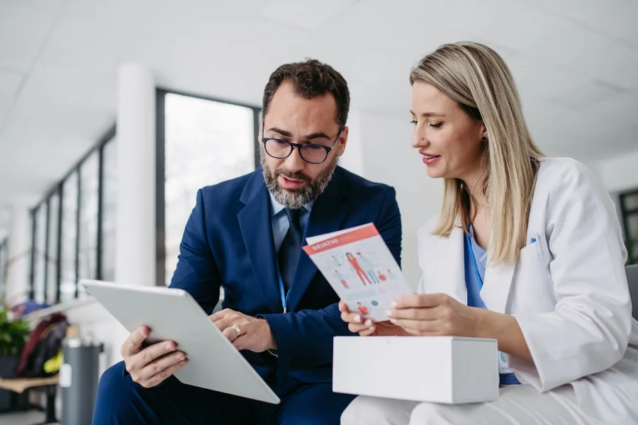 Insight-driven sales coaching: Sales coach and professional reviewing insights and data together on a tablet